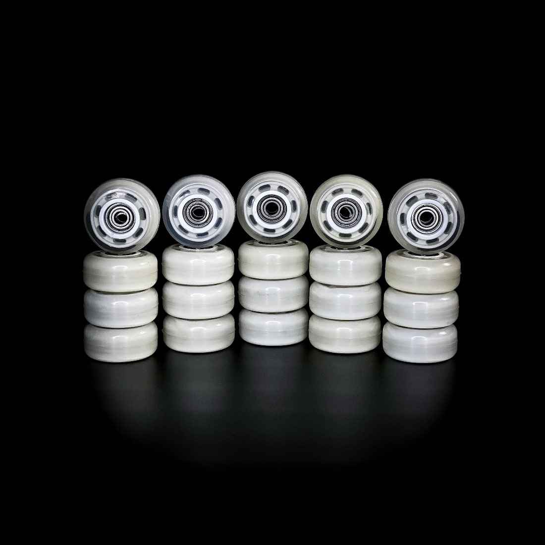 Набір з 20 прозорих коліс для роликових кросівок LieKick з вбудованими підшипниками, розташованих вертикальними стопками на чорному фоні.